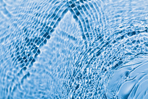 离焦的蓝色透明水面纹理与波浪和涟漪。抽象的背景。图片下载