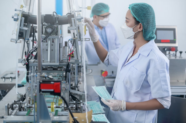现代工厂生产外科口罩的工人，新冠病毒防护和医疗理念。图片下载