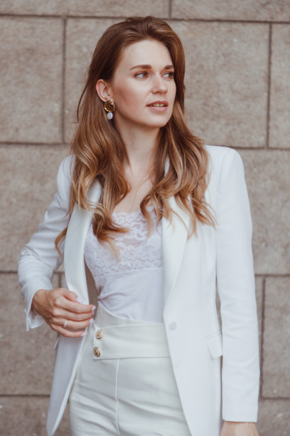 自信优雅的女子穿着白色运动夹克在户外看着别处。商务风格。图片下载