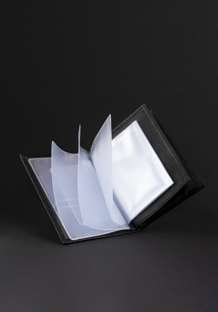 手工制作的黑色皮革制品。漂浮皮革护照封面，漂浮皮革钱包。手工制作男皮革制品。副本的空间。现代的照片。黑色背景图片下载