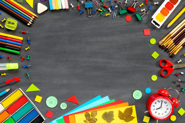 颜料，刷子，毡头笔，铅笔都在学校的黑板上。剪刀，纸和其他学习用品。红色闹钟俯视图。图片下载