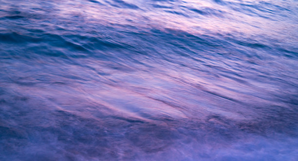 黄昏的海浪与美丽的纹理背景，反射和图案，紫色和蓝色混合。抽象慢拍速度照片。图片下载
