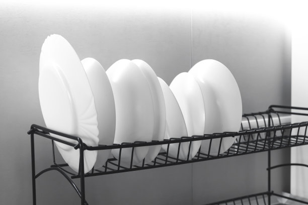 干燥架与干净的白色盘子在餐桌上在现代厨房室内背景照片图片下载