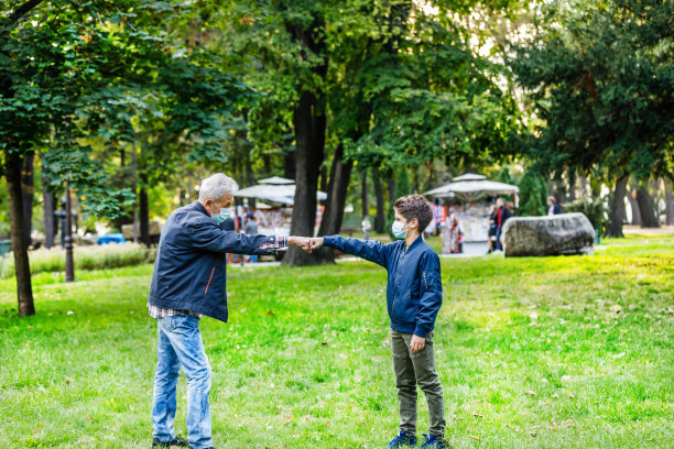 爷爷和他的孙子用肘打招呼以避免传播病毒图片下载