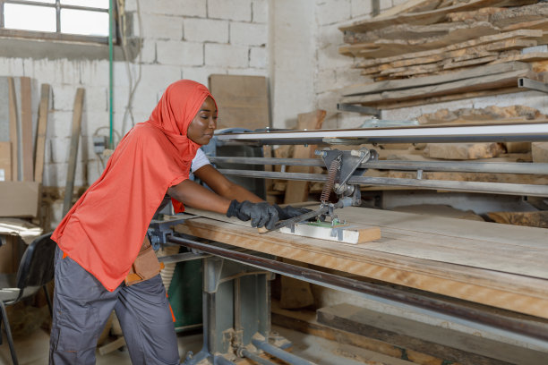 一名女木工正在一个大车间使用砂光机工作。图片下载