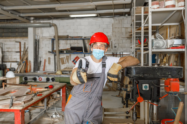 在冠状病毒感染期间，一位自信的木工在他的工作室里。图片下载