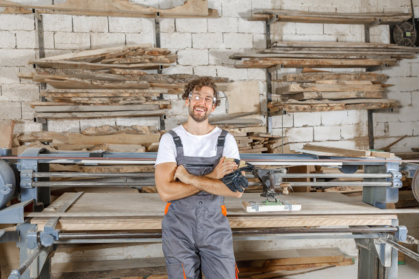 一个快乐而自信的木匠在他的工作室的照片。图片下载