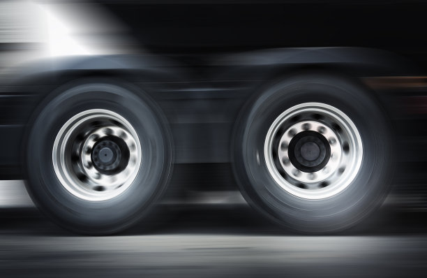 半卡车车轮旋转的速度运动模糊。卡车在路上行驶。工业货运卡车运输。图片下载