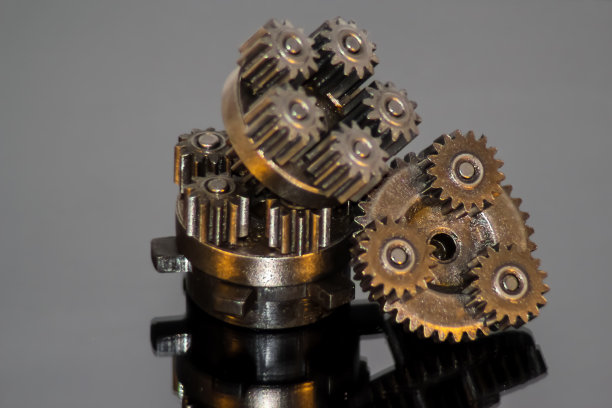 反射的部分机构，齿轮，堆叠在一个笼子，在一个灰色背景上的镜子表面。图片下载
