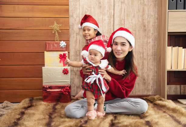 亚洲母亲和婴儿和儿童女孩与圣诞礼物木制背景图片下载