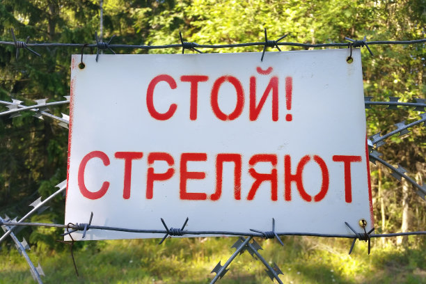 铭文“停止!“在俄罗斯秘密设施周围的铁丝网上用俄语射击”图片下载