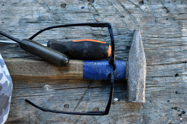 锤子螺丝刀工具和玻璃杯在板上图片下载