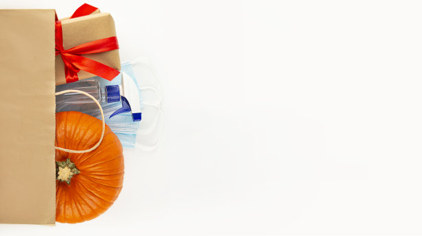 顶视图纸袋内装新鲜南瓜、礼品盒、消毒防毒口罩。为万圣节或感恩节购物。横幅。平的。副本的空间。图片下载