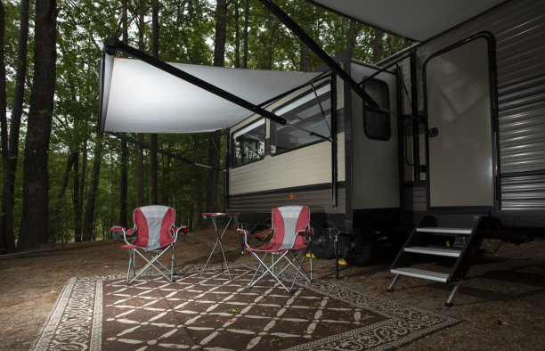 黄昏时分，露营地一辆旅行拖车前的两个红色座位图片下载