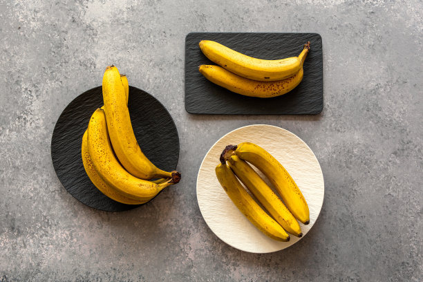黑色盘子上的香蕉。图片下载