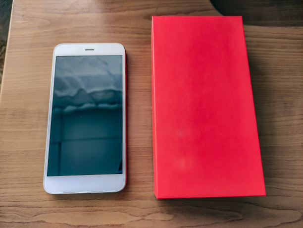 木桌上有盒子的智能手机，特写镜头图片下载