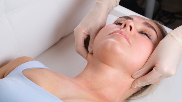 在美容院为年轻女性做面部按摩时做下巴按摩图片下载