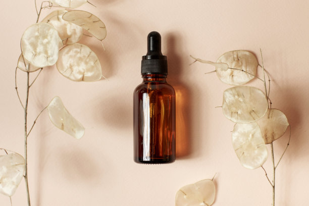 棕色血清或油玻璃模拟瓶与移液管在淡粉色背景。月神复活的背景。天然有机美容、美容、皮肤科学的概念。平躺，靠近。图片下载