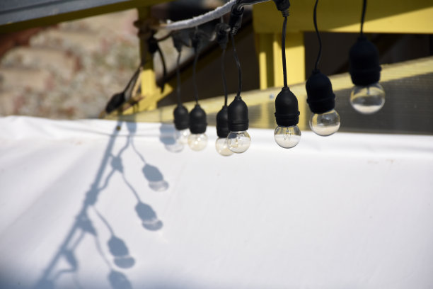 户外挂有阴影的灯泡，选择从右边第三个灯泡聚焦。图片下载