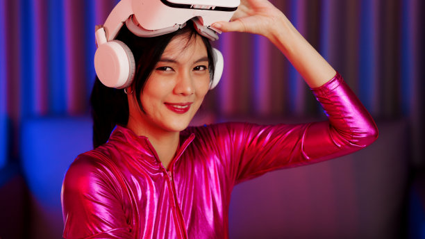 年轻的亚洲女性正在使用虚拟现实耳机。霓虹灯工作室肖像。虚拟现实、模拟、游戏和未来技术的概念。亚洲女人在卧室里玩游戏。图片下载