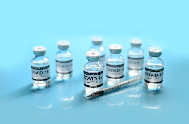 泰国新冠肺炎疫苗玻璃瓶和注射器，蓝色背景，蓝色表面。病毒在世界各地传播。有选择性的重点。图片下载