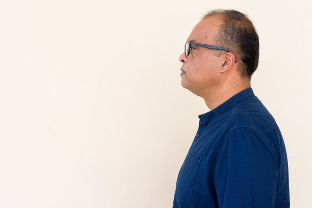 印度人的侧面视图对着朴素的墙在户外图片下载