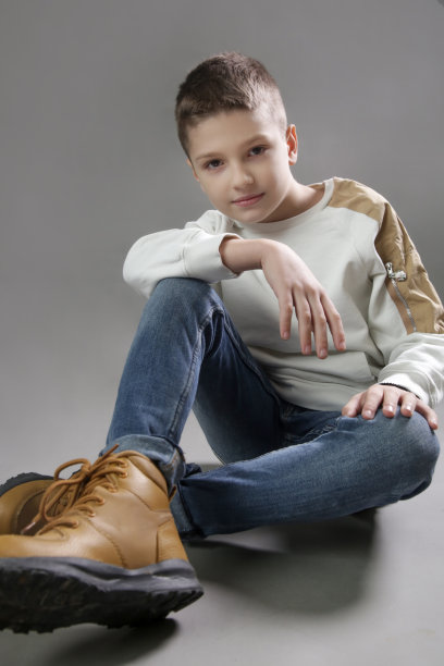 在灰色背景上的英俊学生的画室肖像。图片下载