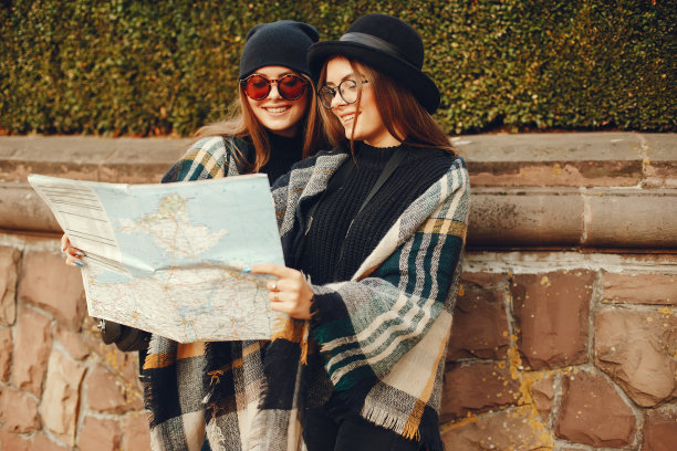 两个年轻的女孩在秋天的城市和公园里漫步图片下载