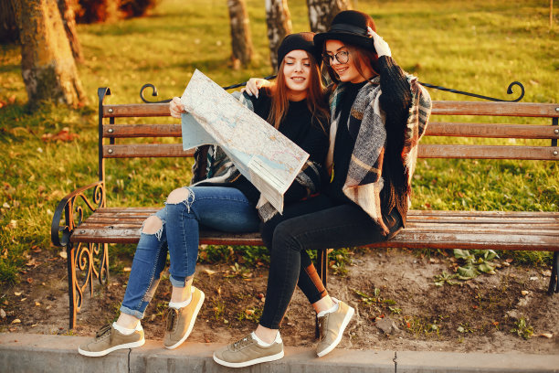 两个年轻的女孩在秋天的城市和公园里漫步图片下载