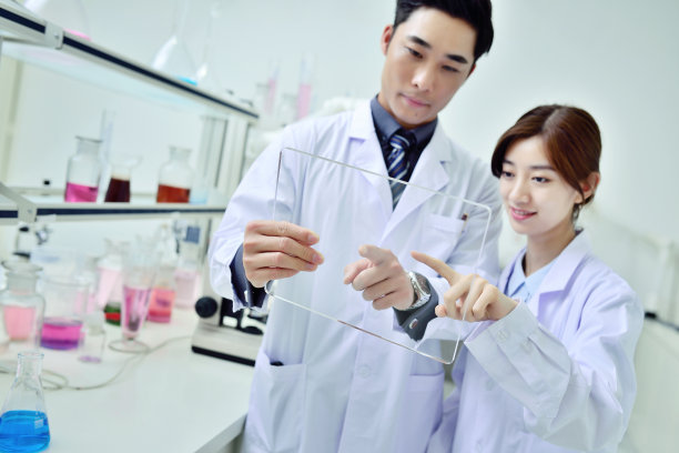 两位科学家在实验室工作和观察数字平板电脑图片下载