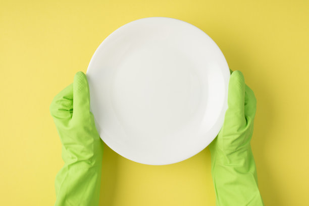 上面照片的板和手在绿色手套隔离在黄色的背景图片下载