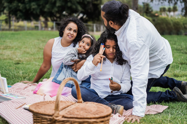 快乐的印度家庭和孩子们在城市公园户外画画-主要关注女孩的脸图片下载