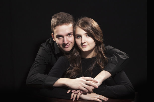 黑色背景下的年轻情侣肖像图片下载