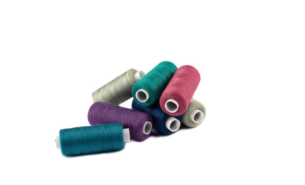 白色背景上有彩色线的线轴。图片下载