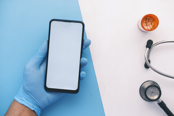 手戴乳胶手套，手持绿色屏幕的智能手机图片下载