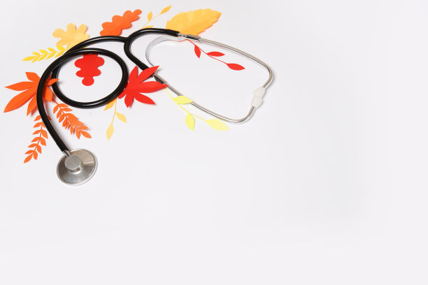 听诊器与红色和黄色的秋天纸叶子在浅色背景与复印空间图片下载