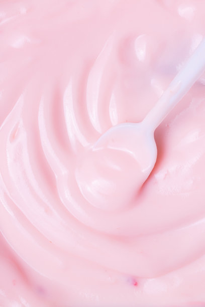 宏酸奶，草莓冰冻酸奶背景特写。草莓冰淇淋质地接近。前视图。粉红色水果冰淇淋的背景与小块浆果图片下载