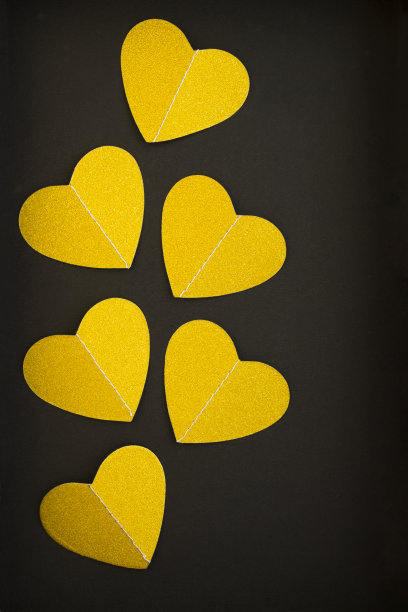 俯视图的金色心在黑暗的背景图片下载