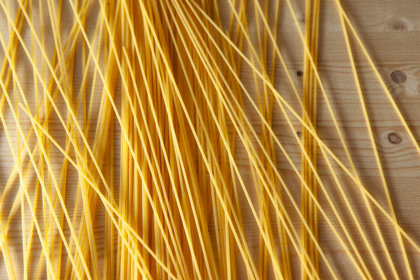 黄色的意大利面撒在桌子上。意大利食品的概念。意大利艺术背景。高质量的照片图片下载