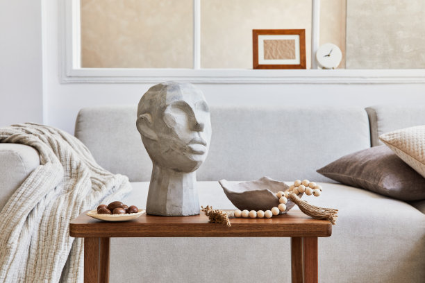 创意构图时尚舒适的客厅与模拟海报框架，灰色沙发，木制咖啡桌和个人配件。米色的中性颜色。模板。图片下载