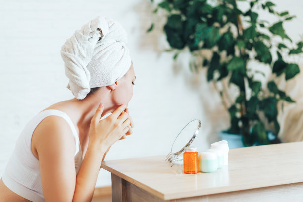 年轻的女孩压痘痘和黑头在她的脸上图片下载