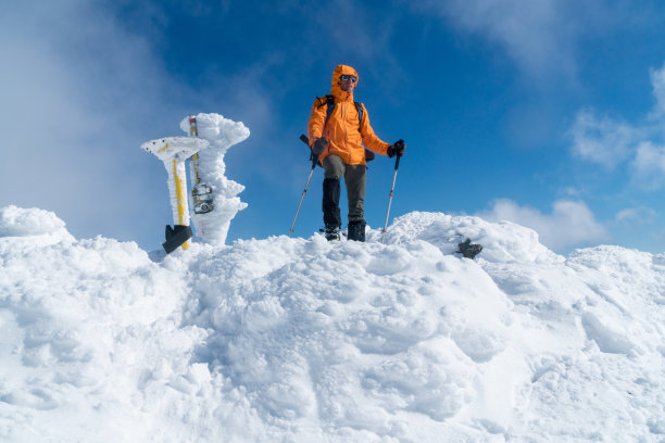 登山运动员穿着鲜橙色的软壳夹克图片下载