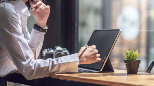 年轻的亚洲女商人在咖啡馆使用平板电脑。图片下载