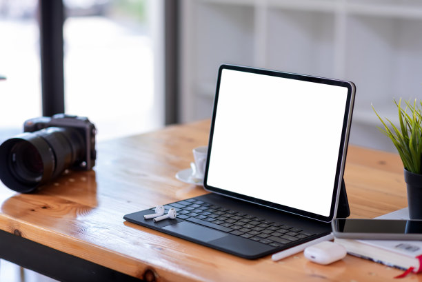 工作空间平板电脑白屏耳机摄像头智能手机放在办公室木桌。图片下载