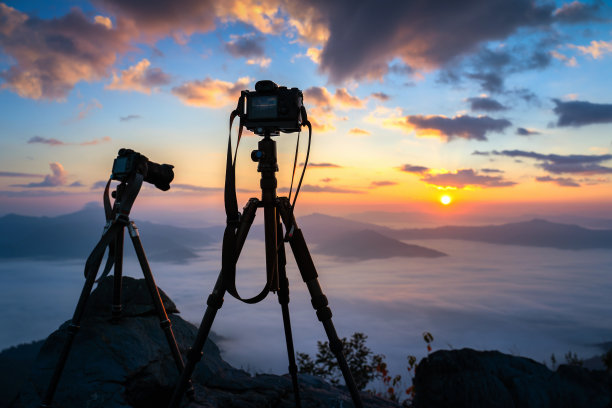 日出时三脚架上的相机剪影。图片下载