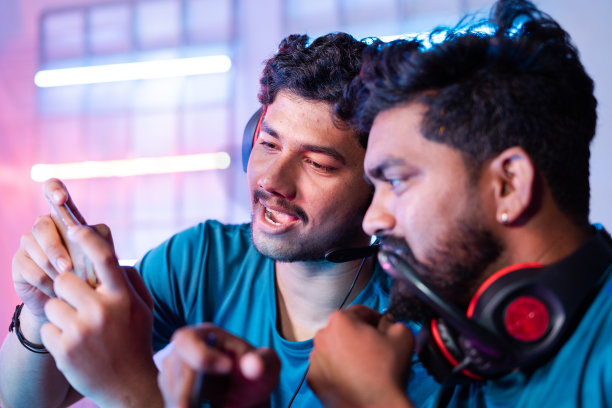 在电子竞技冠军赛联赛中，两名游戏玩家通过查看手机讨论游戏玩法——团队合作、战略、团结和多人比赛的概念。图片下载