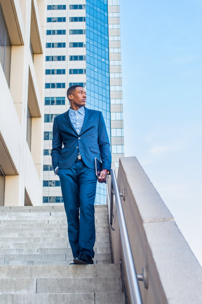 一个年轻的黑人走在纽约办公楼外的楼梯上图片下载