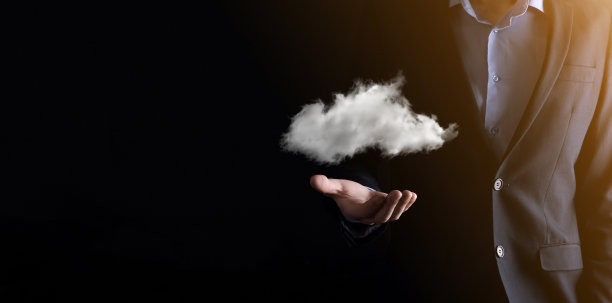 商人男人手捧云。云计算的概念，年轻的商人与云在他的手。云服务的概念。图片下载