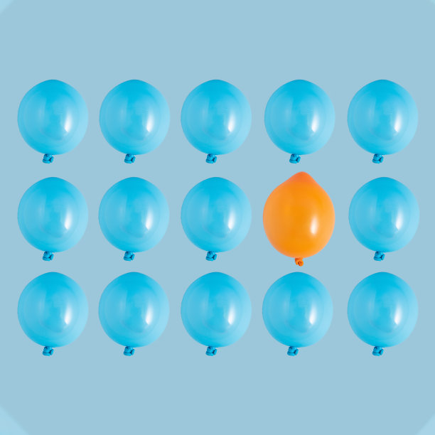 蓝色气球图案，浅蓝色背景上有一个橙色的气球。独立，个性，个人主义，创造力，独特性创造性的最小概念。图片下载
