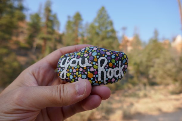 善良的岩石与彩绘你岩石的信息举在手中图片下载